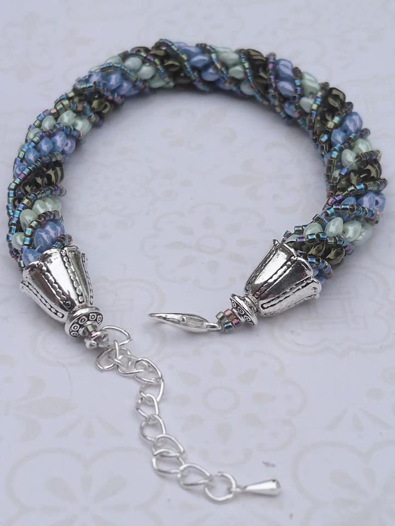 Needle-woven Flavie bracelet spiraled with Matubo superduo beads and Miyuki D\u00e9licas greenbluebronze primers without nickel