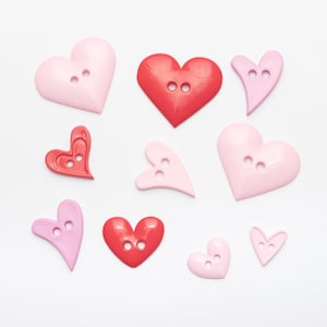 Peut inclure: Assortiment de boutons en forme de cœur de couleur rose et rouge. Les boutons ont deux trous chacun et sont parfaits pour les projets de bricolage.