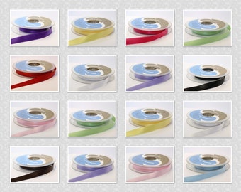 May include: Assortment of 12 spools of satin ribbon in various colours, including purple, yellow, red, green, pink, black, light blue, lavender, and white. Each spool is wound with ribbon and has a blue label.