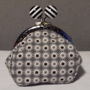 Black and white wallet with clasp decorated with striped balls