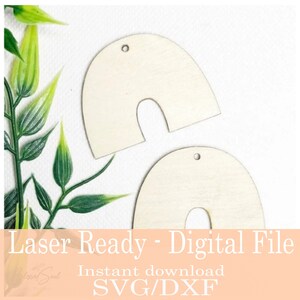 May include: Two unfinished wooden arch-shaped earring blanks with a small hole at the top for hanging. The image also includes green leafy sprigs and the text "Laser Ready - Digital File" and "Instant download SVG/DXF".