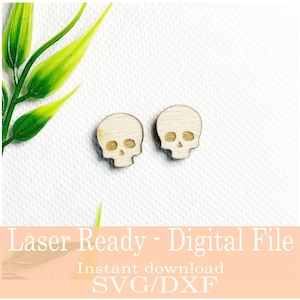 May include: Two small, wooden skull-shaped cutouts. The skulls have eye and nose cavities, and a detailed jawline. The text "Laser Ready - Digital File" and "Instant download SVG/DXF" is visible at the bottom of the image.