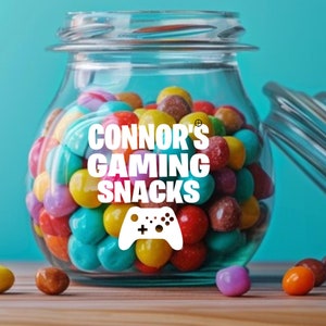 May include: A glass jar filled with colorful candy, labeled "Connor's Gaming Snacks" with a white video game controller graphic.