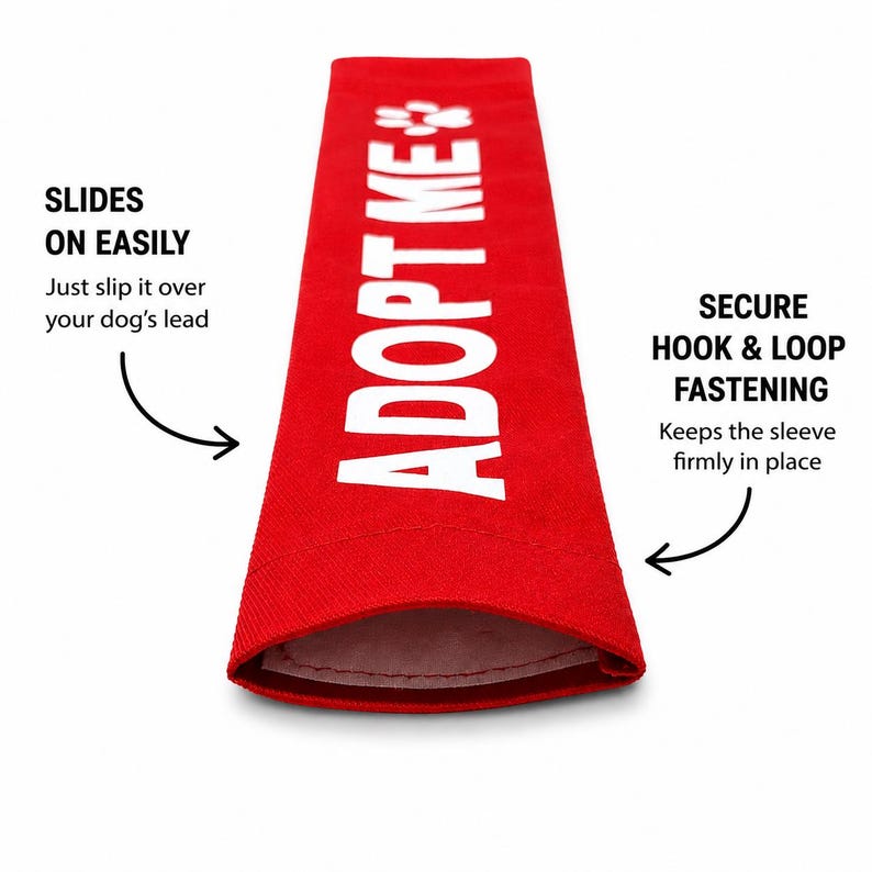 May include: A bright red rectangular dog leash sleeve featuring the white text ADOPT ME and a paw print icon. The sleeve includes text indicating it slides on easily over a dog's lead and utilizes a secure hook and loop fastening system.