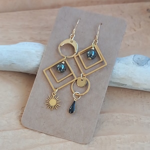 May include: Gold earrings with black beads and geometric shapes, including circles, squares, and a sunburst design.  Clem et Tom.