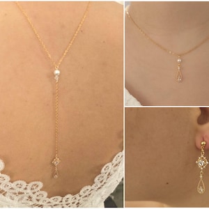 Könnte beinhalten: Eine goldene Halskette mit einer Perle und einem tropfenförmigen Anhänger. Die Kette wird am Nacken getragen. Ein Paar goldene Ohrringe mit tropfenförmigen Anhängern sind ebenfalls abgebildet.