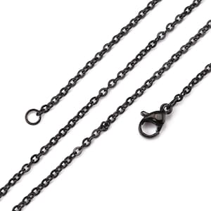 Op de afbeelding: Close-up van een zwarte ketting met een karabijnsluiting. De ketting is gemaakt van kleine, ovaalvormige schakels. De ketting wordt tegen een witte achtergrond getoond.