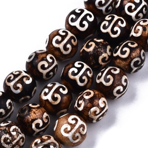 May include: A strand of brown and white beads with a swirling pattern. The beads are round and have a smooth, polished finish.