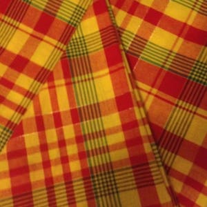 Peut inclure: Un tissu à carreaux jaunes et rouges avec un motif à carreaux verts et bruns.