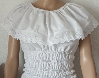 May include: White peasant top with a ruffled neckline and short sleeves. The top has a gathered elastic waistband and a delicate lace trim.