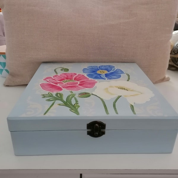 boite en bois à  compartiments avec un décor de fleurs pastel sur un fond bleu clair à l' aspect vieilli,25 x 25 x 7 cm.