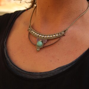 May include: A brown and beige macrame necklace with a turquoise gemstone pendant.
