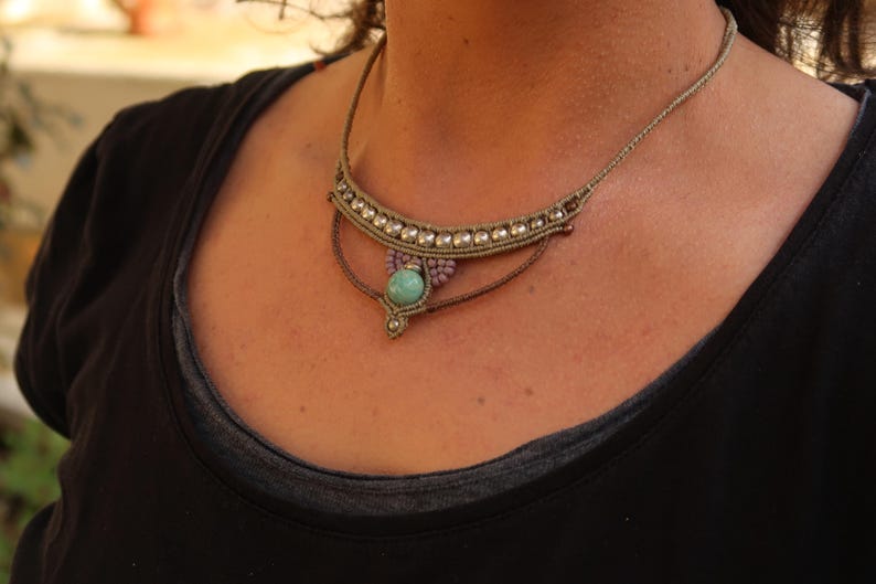 May include: A brown and beige macrame necklace with a turquoise gemstone pendant.