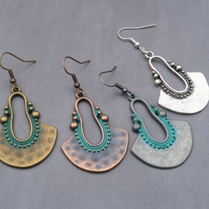 May include: Four pairs of dangle earrings with a fan-shaped design. The earrings are made of metal and have a turquoise blue enamel finish. The earrings are available in three different colors: silver, bronze, and copper.