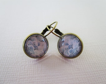 May include: A pair of round drop earrings featuring a bronze-toned metal setting and a glass cabochon inlay. The surface of each earring displays a repeating pattern of overlapping blue and light pink semicircular arcs in a fan-like design.