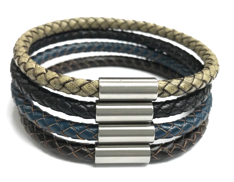 May include: A multi-layered leather bracelet with a braided design in black, brown, beige, and blue. The bracelet has a silver magnetic clasp.
