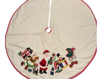 Falda para árbol de Navidad con apliques de House Of Hatten, estilo taller de Papá Noel, color crema.