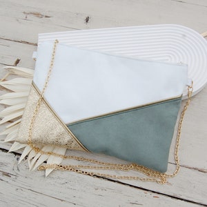 Può includere: Una pochette bianca e verde salvia con una catena dorata. La pochette ha un design geometrico con un accento dorato.