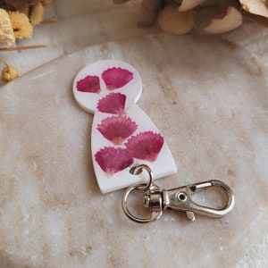 樹脂と乾燥したポエツカーネーションの花で作られたショッピングカートのトークン。ショッピングアクセサリー。ショッピングカートトークンキーチェーン。