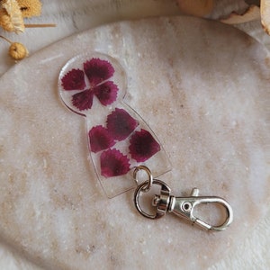 樹脂と乾燥したポエツカーネーションの花で作られたショッピングカートのトークン。ショッピングアクセサリー。ショッピングカートトークンキーチェーン。