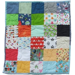 Peut inclure: Une courtepointe en patchwork avec une variété de tissus et de motifs colorés. La courtepointe est composée de carrés, chacun avec un design différent. Certains des motifs incluent des animaux, des formes géométriques et des motifs floraux.