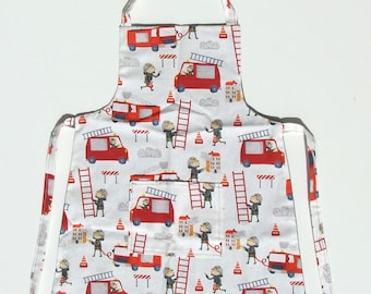 May include: White apron with a red, yellow, and blue fire truck and firefighter pattern. The apron has a pocket and adjustable straps.