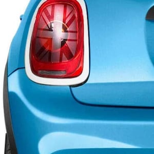 May include: A blue Mini Cooper with a Union Jack design on the rear light. The car has a white roof and a black rear bumper.