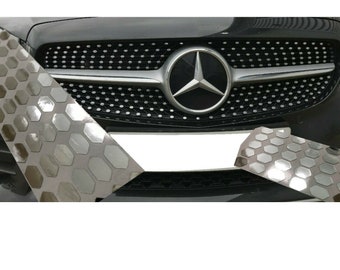 May include: A black car with a silver grille and a Mercedes-Benz logo. The grille has a honeycomb pattern.