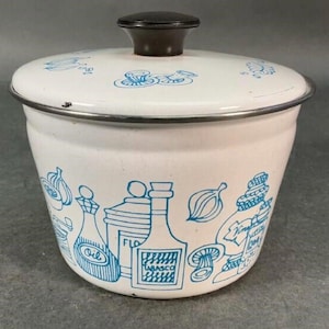 May include: White enamel kitchen canister with a lid and a dark brown knob. The canister is decorated with blue illustrations of kitchen items, including bottles, onions, and mushrooms. The rim is silver.