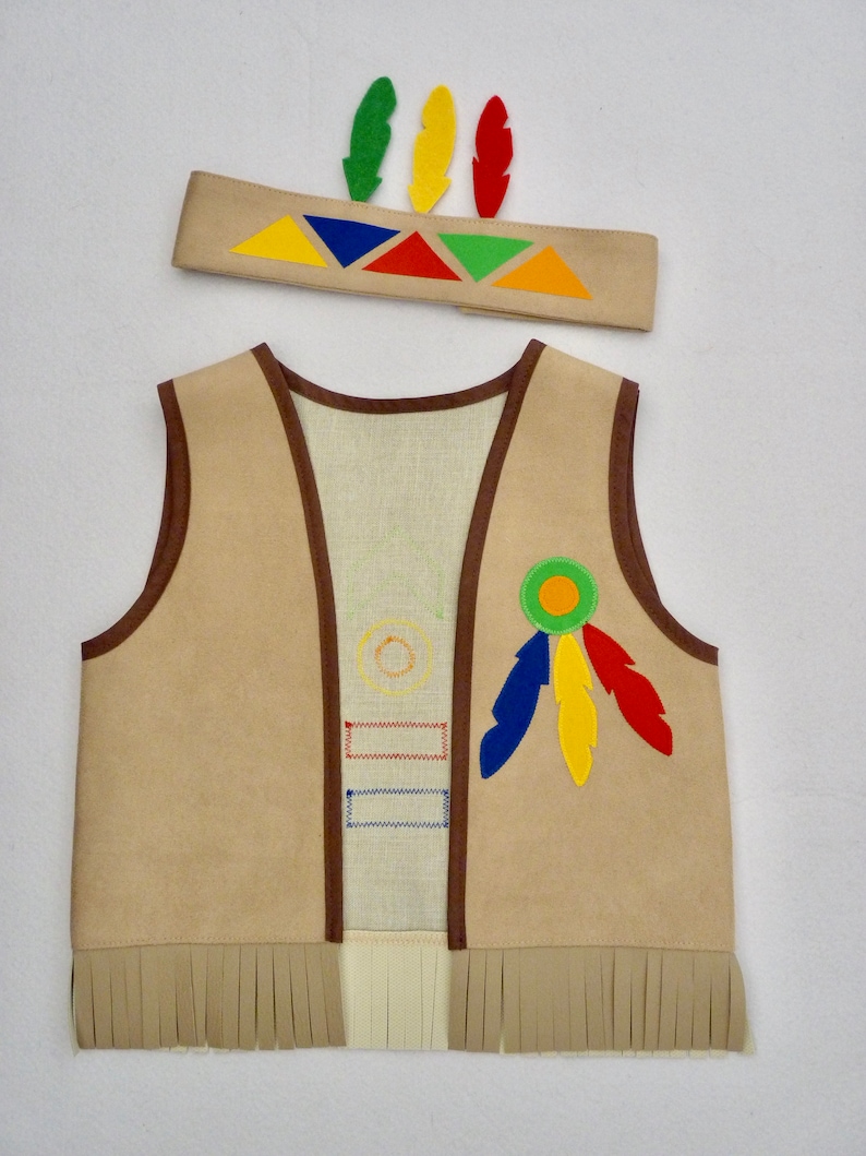 K&ouml;nnte beinhalten: Eine braune Kunstlederweste mit Fransenbesatz und bunten Filzapplikationen, darunter Federn und geometrische Formen. Die Weste ist Teil eines indianisch inspirierten Kost&uuml;ms.