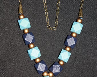 Collier sautoir en bois bleue pompon