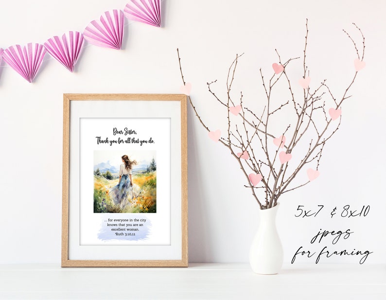 May include: A framed print with a watercolor painting of a woman walking in a field. The text reads "Dear Sister, Thank you for all that you do." and "for everyone in the city knows that you are an excellent woman. Ruth 3:10,11". The print is on a white surface with a vase of pink hearts on branches.