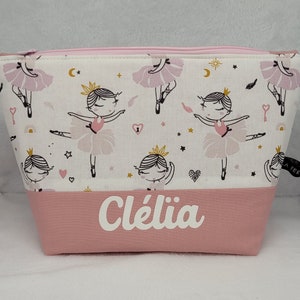 Peut inclure: Pochette zippée rose et blanche avec un imprimé de ballerine et le nom "Clélia" brodé sur le devant.