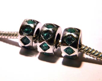 May include: Three silver charm beads with green gemstone accents. The beads are round and have a faceted design. The beads are strung on a silver chain.