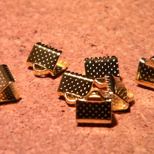 May include: Gold-toned metal clasps with a textured surface. These clasps are used for jewellery making and crafting.