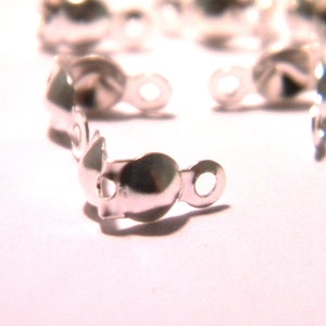 Peut inclure: Fermoirs en métal argenté de forme arrondie avec un petit trou de chaque côté. Les fermoirs sont conçus pour être utilisés pour attacher des bijoux ou d'autres objets artisanaux.