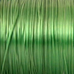 Peut inclure: Gros plan d'une bobine de fil vert. Le fil est enroulé serré et a une finition lisse et brillante.