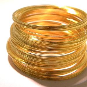 Op de afbeelding: Een stapel gouden metalen ringen, elke ring is iets anders in grootte, waardoor een aflopend effect ontstaat.