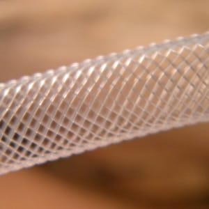 May include: Close-up of a clear, flexible, braided hose with a diamond-shaped pattern.
