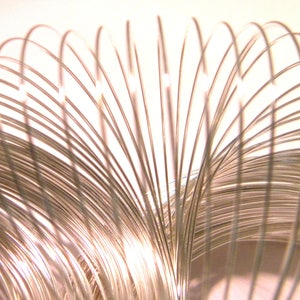 Op de afbeelding: Een zilveren metalen slinky-speelgoed, een klassiek veer-speelgoed dat uitrekt en samentrekt.