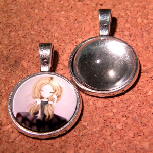 Peut inclure: Deux breloques pendantes argentées, l'une avec un dôme en verre transparent et l'autre avec une image imprimée d'une fille aux cheveux blonds et à la robe rose.