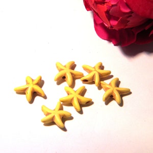 May include: Six yellow starfish-shaped beads with a hole in the center. The beads are made of a smooth, polished material and have a slightly textured surface.