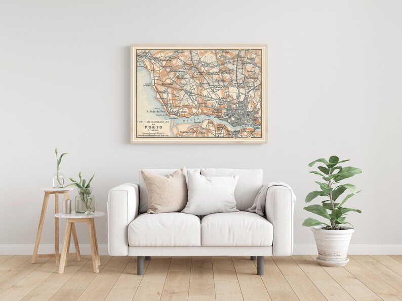 Peut inclure: Une carte vintage de Porto, au Portugal, encadr&eacute;e dans un cadre en bois clair et accroch&eacute;e &agrave; un mur blanc au-dessus d'un canap&eacute; blanc. La carte est dans des tons de brun, bleu et vert, et comprend le texte "CIVIDADE PORTUENSE - PORTO - 1900".