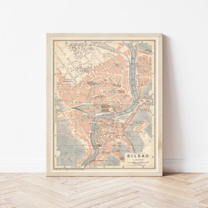 Peut inclure: Carte vintage de Bilbao, en Espagne, imprimée en noir et blanc avec des surlignages orange. La carte montre les rues, les bâtiments et les voies navigables de la ville. Le titre "Bilbao 1:35000" est imprimé dans le coin inférieur droit.