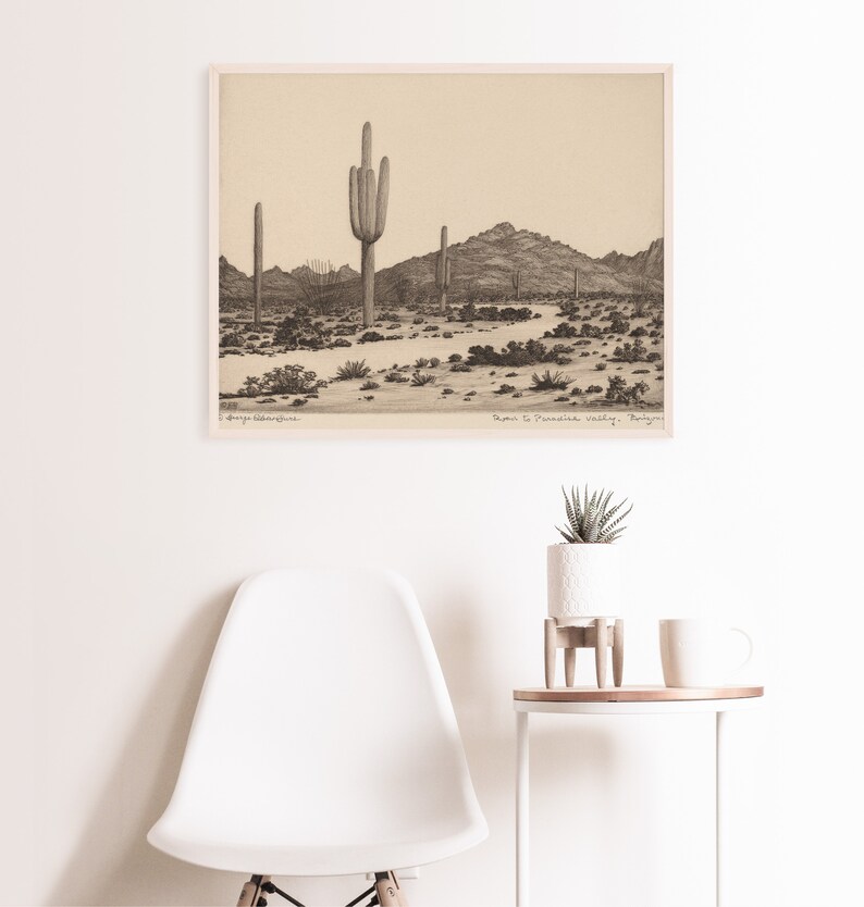 K&ouml;nnte beinhalten: Eine Schwarzwei&szlig;zeichnung mit Bleistift einer W&uuml;stenlandschaft mit hohen Kakteen und Bergen im Hintergrund. Die Zeichnung tr&auml;gt den Titel "Road to Paradise Valley, Arizona".