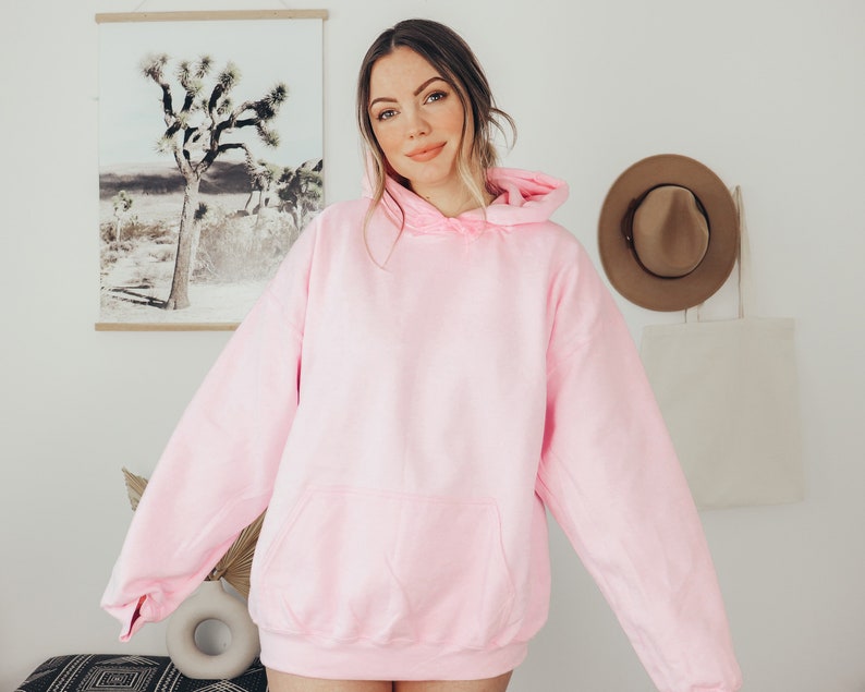 Puede incluir: Una sudadera con capucha rosa claro con un bolsillo delantero y una capucha con cord&oacute;n. La sudadera est&aacute; hecha de un material suave y es de color liso. La sudadera con capucha es de estilo casual y es adecuada para el uso diario.