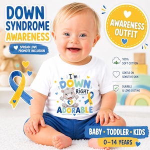 May include: A baby wearing a white t-shirt with the text "I'm Down Right Adorable" and a cartoon hippo. The shirt is paired with blue shorts. The image promotes Down Syndrome awareness with text and ribbon graphics.