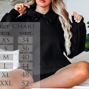 Puede incluir: Una sudadera con capucha negra con cord&oacute;n y mangas largas. La imagen incluye una tabla de tallas con medidas de pecho en pulgadas: XS (34), S (36), M (40), L (44), XL (48) y XXL (52).