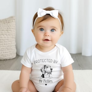 Protegido por un adorable body para amantes de los perros: pelele o camiseta personalizable con más de 90 razas.