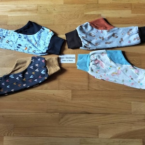 May include: Four pairs of baby leggings in different patterns. The leggings are made of soft, stretchy fabric and have a comfortable fit. The patterns include hearts, animals, and a blue and white design.